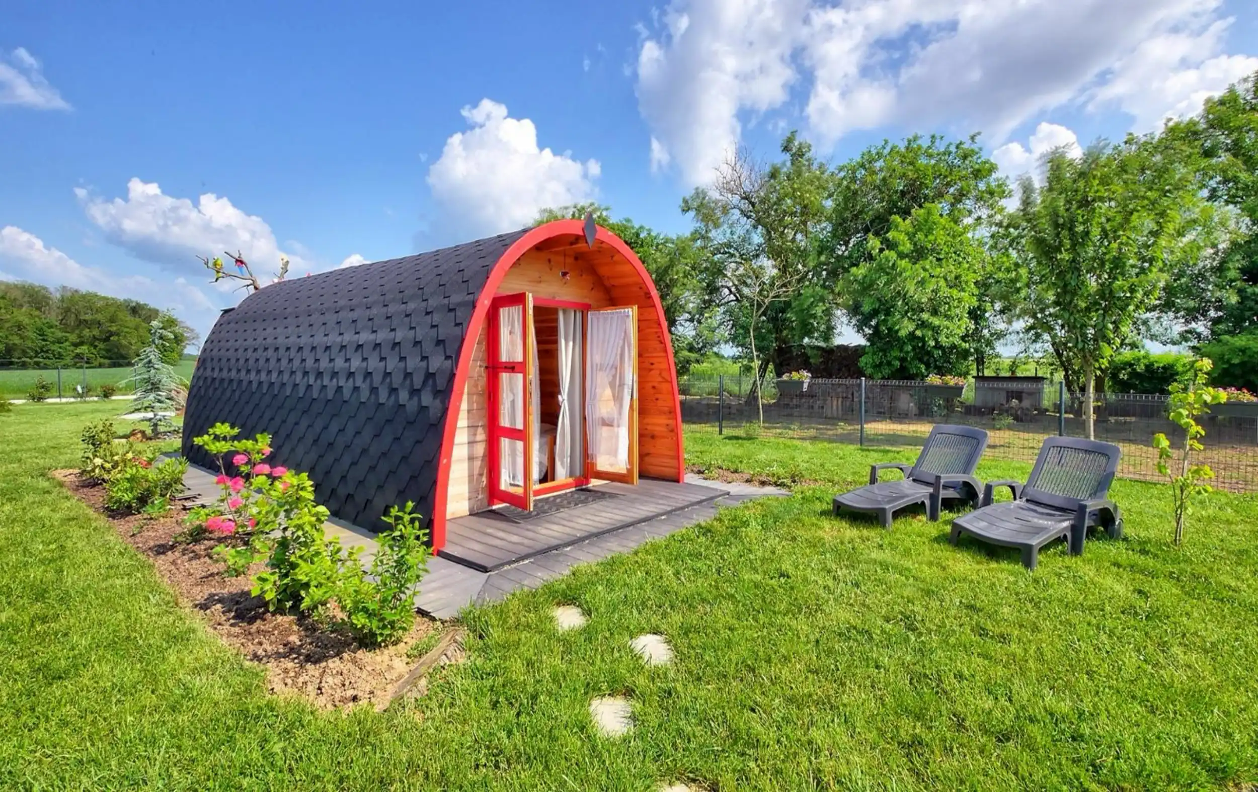Le POD en bois et sa terrasse, hébergement insolite dans le jardin de L’Escale Arc-en-Ciel